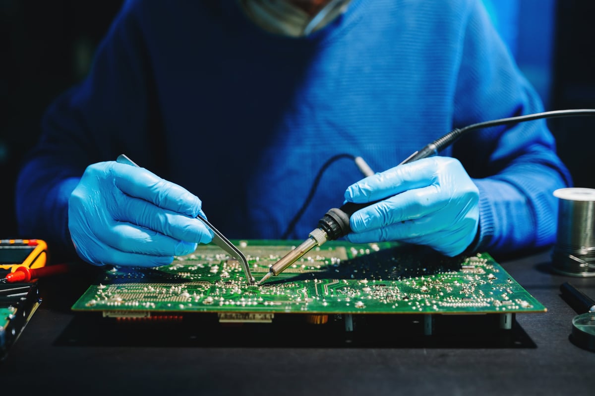 Leiterplatte mit Lötkolben unter dem Mikroskop – Platinenreparatur bei ONEREPEX in Rosenheim